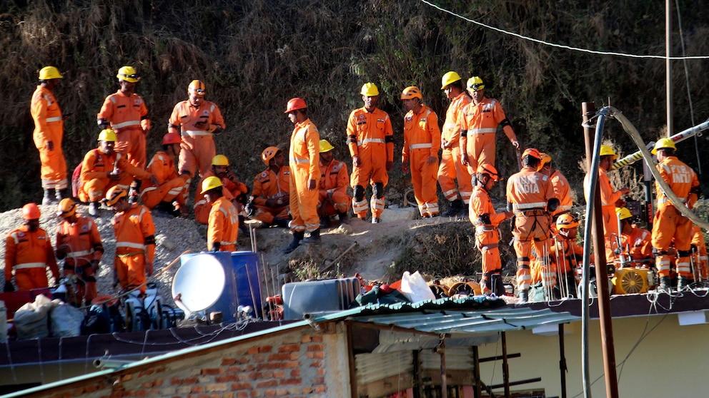 Rescuers rest at the site of an under-construction road tunnel that collapsed in Silkyara in the northern Indian state of Uttarakhand, Friday, Nov. 24, 2023. Rescuers are racing to evacuate 41 construction workers who have been trapped for nearly two weeks. (AP Photo)