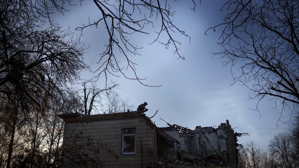 A Ukrainian serviceman stands atop a damaged kindergarten following a Russian drone attack in Kyiv, Ukraine, Saturday, Nov. 25, 2023. Russia launched its most intense drone attack on Ukraine since the beginning of its full-scale invasion on Saturday morning, military officials said. (AP Photo/Felipe Dana)
